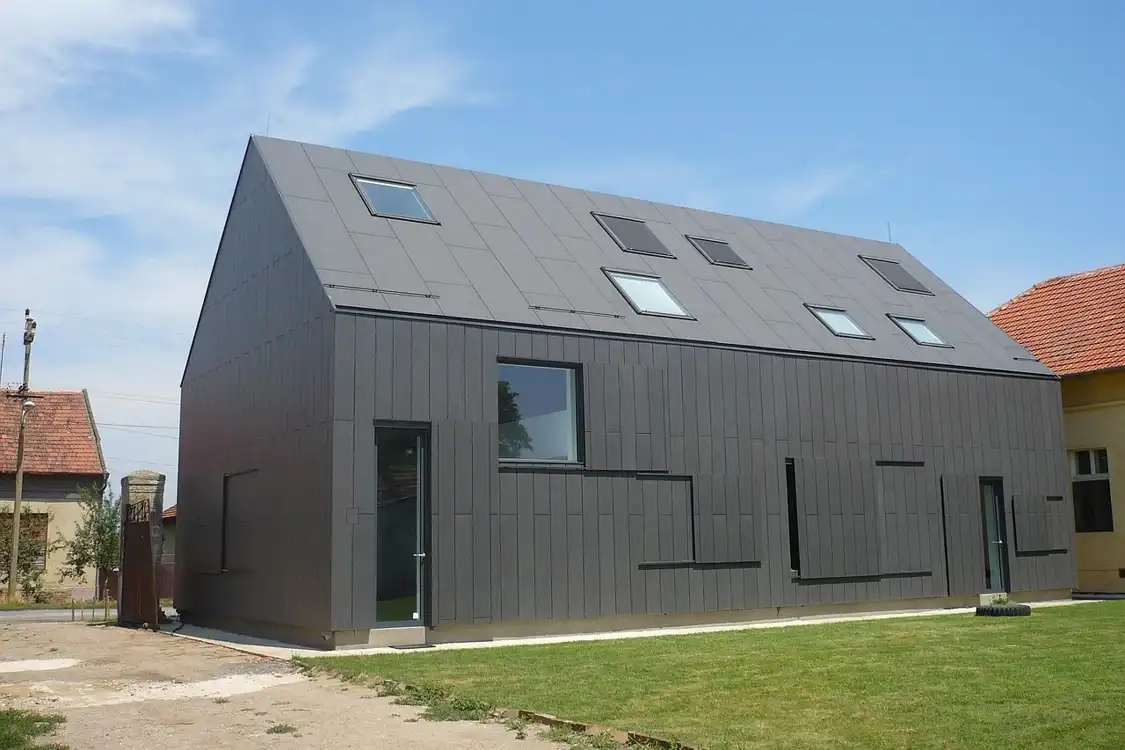 Modern energiatakarékos épület fémes borítással és modern tetőablakokkal
