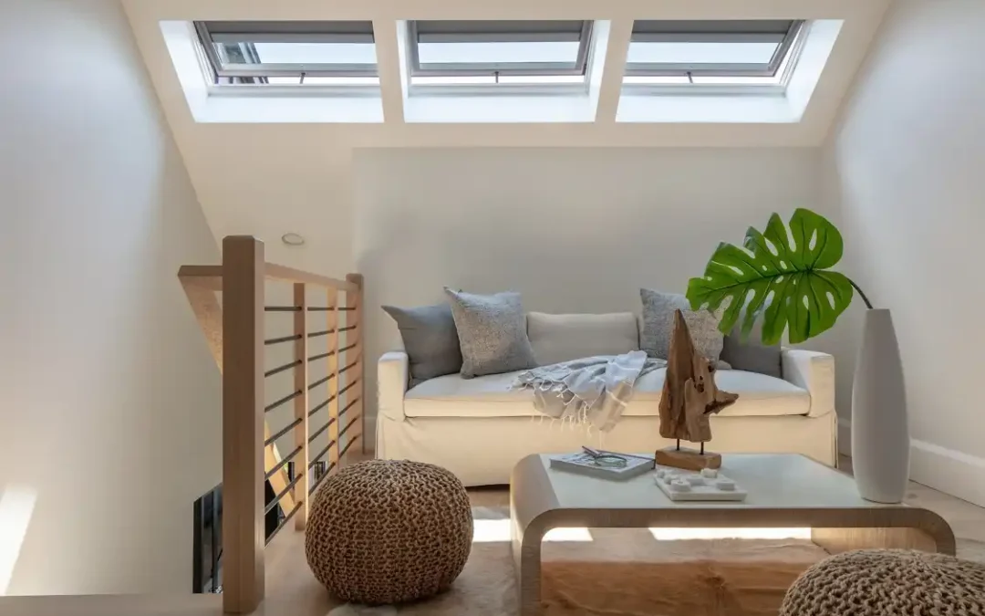 Velux tetőablakok egy lépcsőfordulóban fa korláttal és bútorokkal. Forrás: VELUX USA